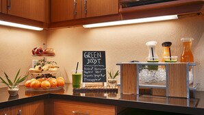 Een ontbijtbuffet met een bord waarop onder andere staan: boerenkool, banaan, appel, biologische yoghurt en ananas.