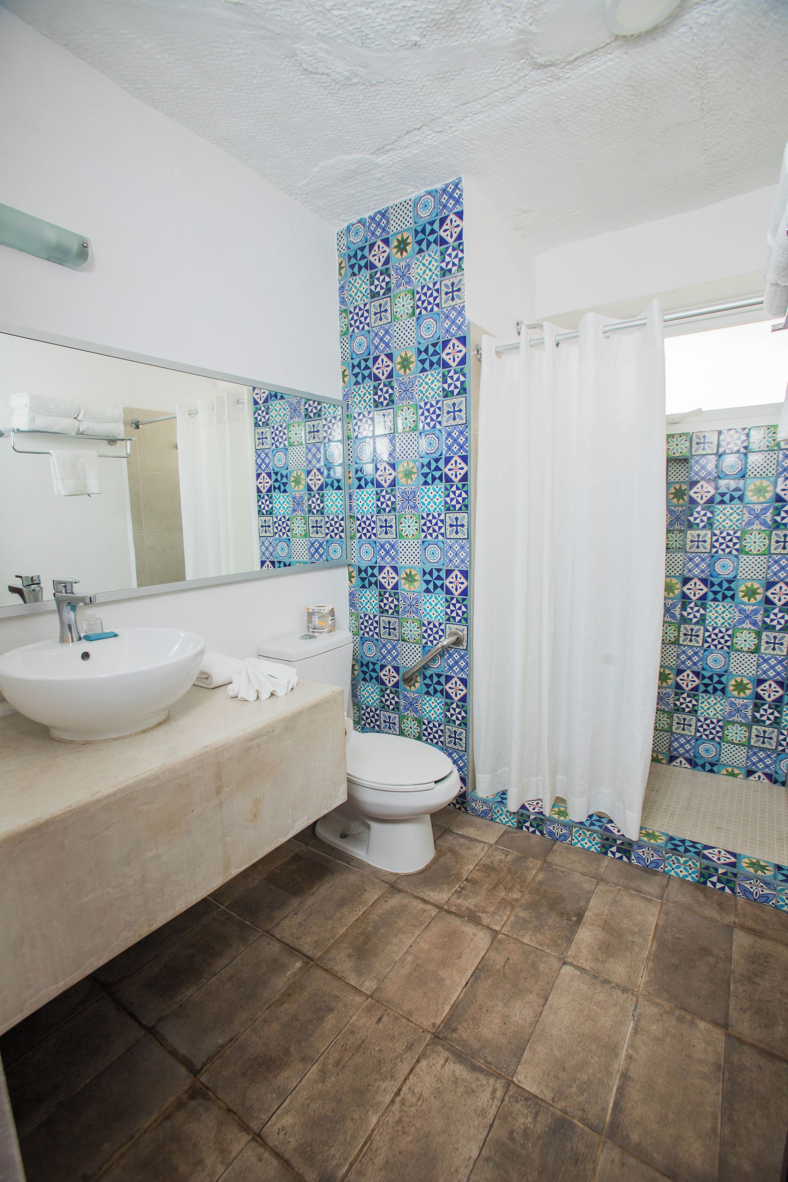 Un baño con lavamanos blanco, inodoro y cortina de ducha.