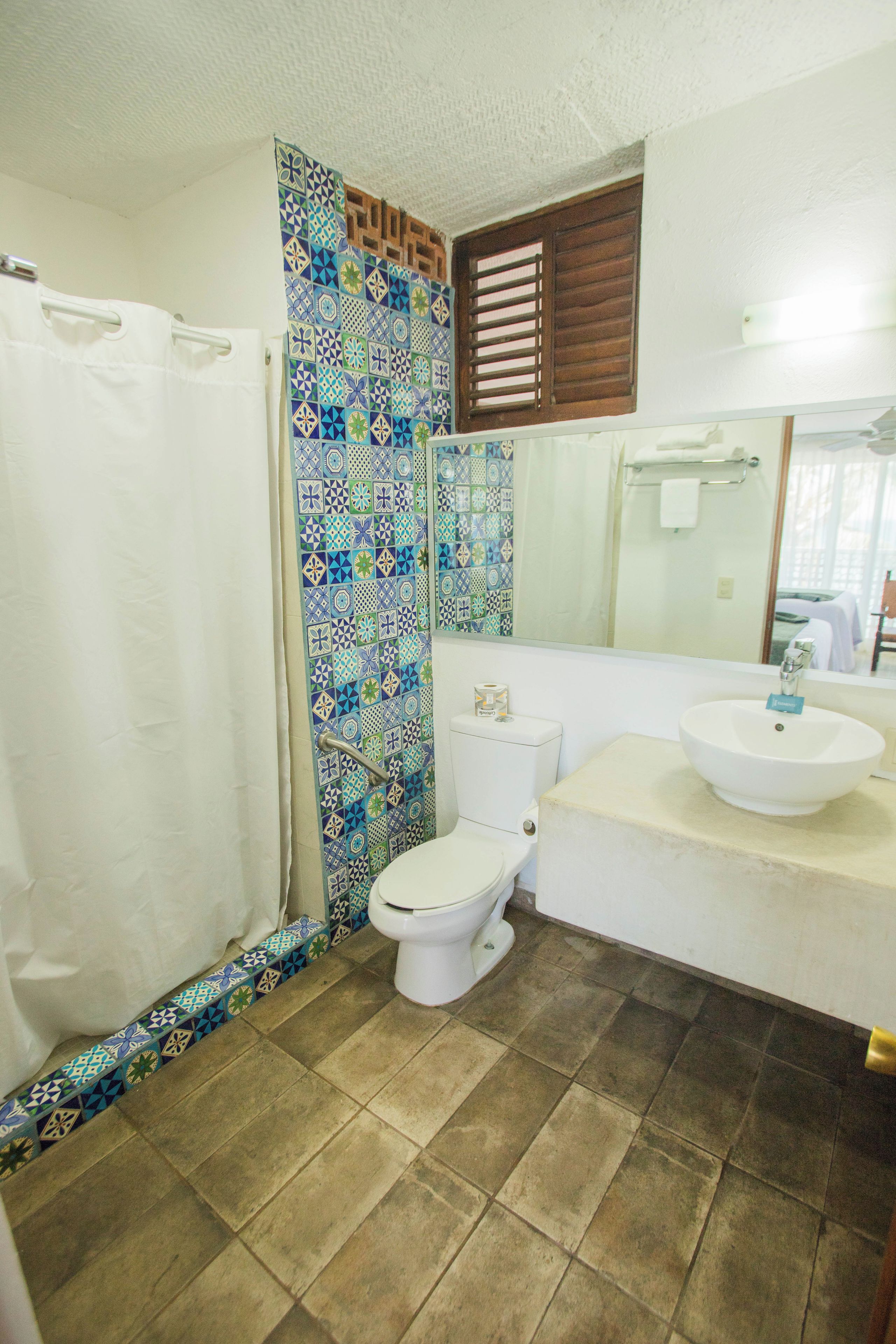 A bathroom with a toilet, sink, and shower.