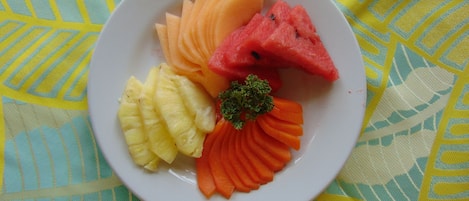 A plate with sliced watermelon, pineapple, and carrots.