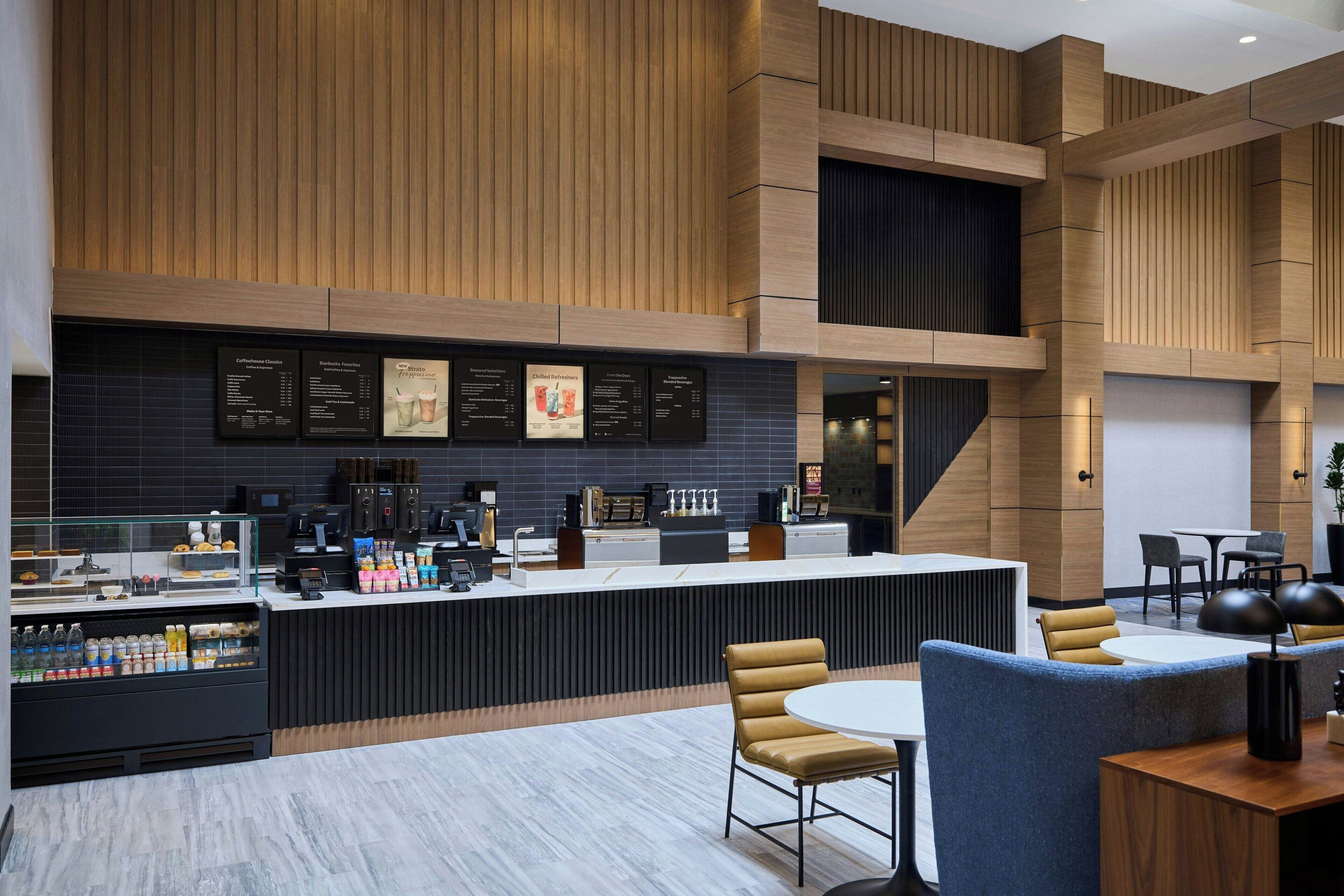 A modern coffee shop with a counter, seating area, and menu boards.