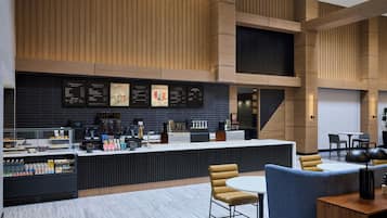 A modern coffee shop with a counter, seating area, and menu boards.