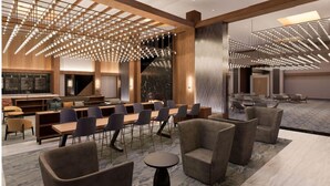 Une salle de conférence moderne, dotée d’une longue table, de nombreuses chaises et d’un luminaire au plafond au design original.