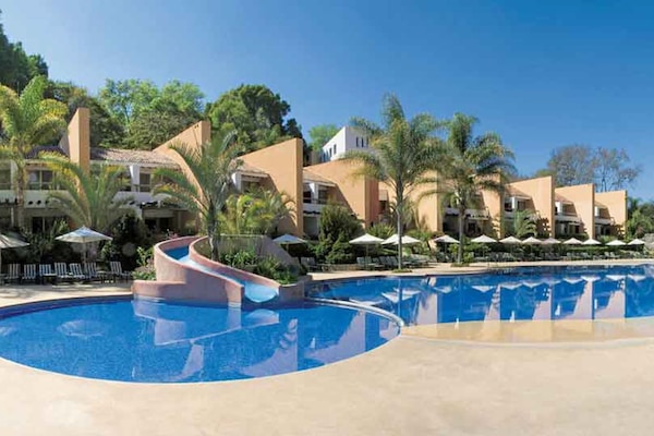 Alberca al aire libre y sombrillas en la alberca