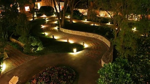 A landscaped garden with winding pathways and illuminated lights. - Hotel Rancho San Diego Grand Spa Resort (Ixtapan de la Sal)