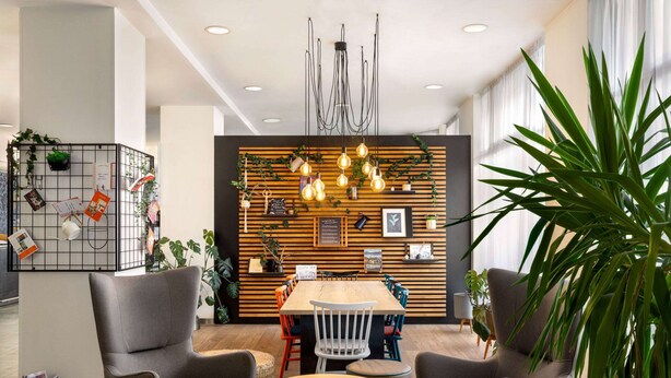 Un espace de salle à manger moderne avec un mur en bois, des luminaires suspendus et une variété de chaises.