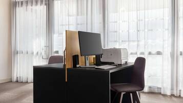 A modern office desk with a computer, keyboard, and speakers.