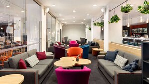 Un espace de détente moderne, avec des canapés, des tables et des plantes suspendues.