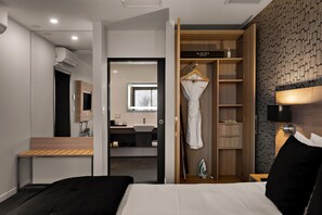 A hotel room with a bed, a bedside table, a wardrobe, and a bathroom visible through an open door. - Sudima Christchurch Airport (Christchurch)