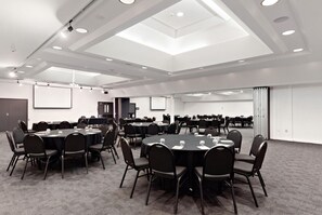 A conference room with round tables, chairs, and a presentation screen. - Sudima Christchurch Airport (Christchurch)