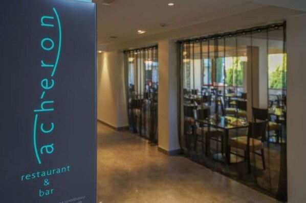 A corridor leading to a restaurant with glass doors and a sign reading "ach-eron restaurant & bar". - Sudima Christchurch Airport (Christchurch)
