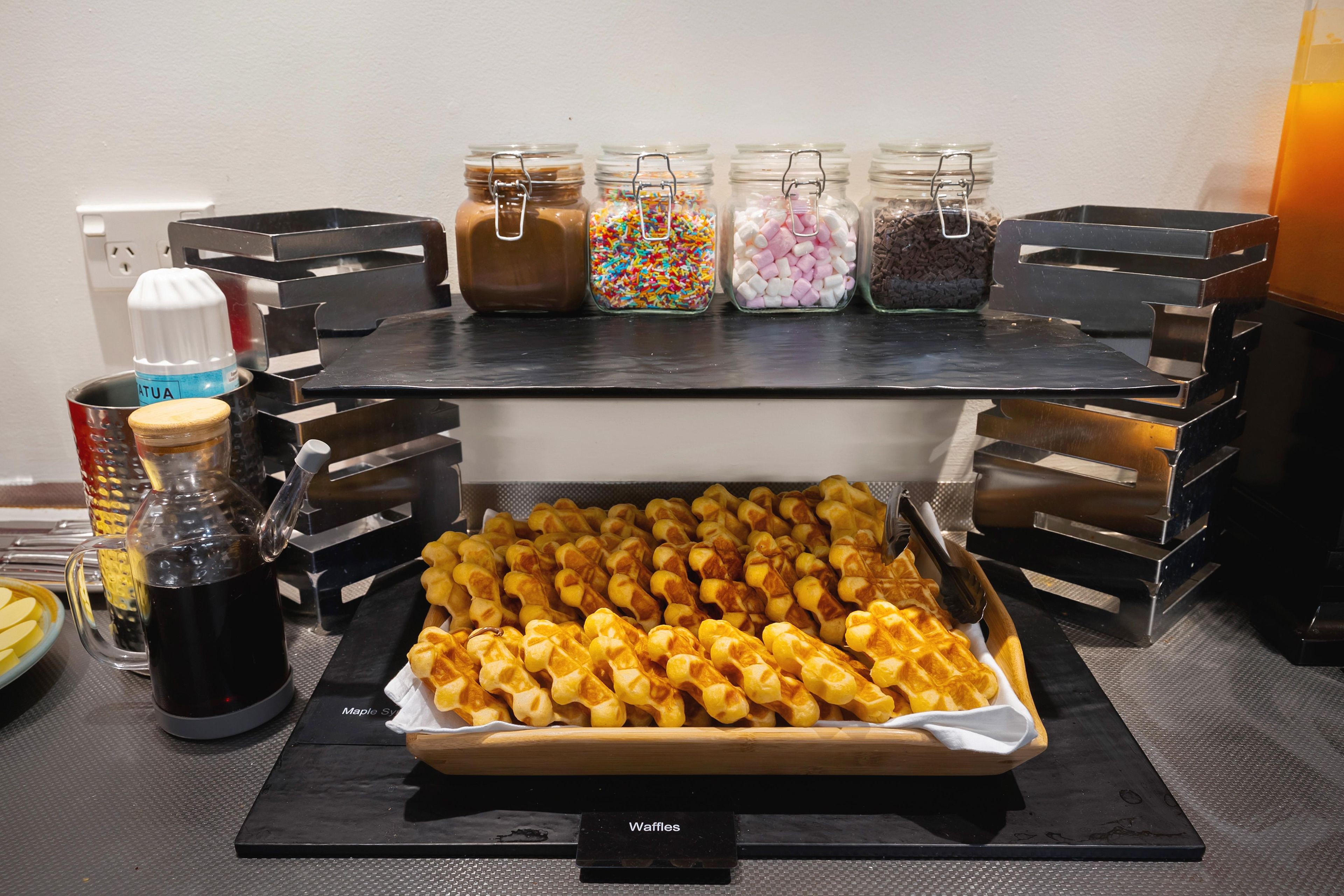 Een buffet met diverse gerechten en bijbehorende sauzen.