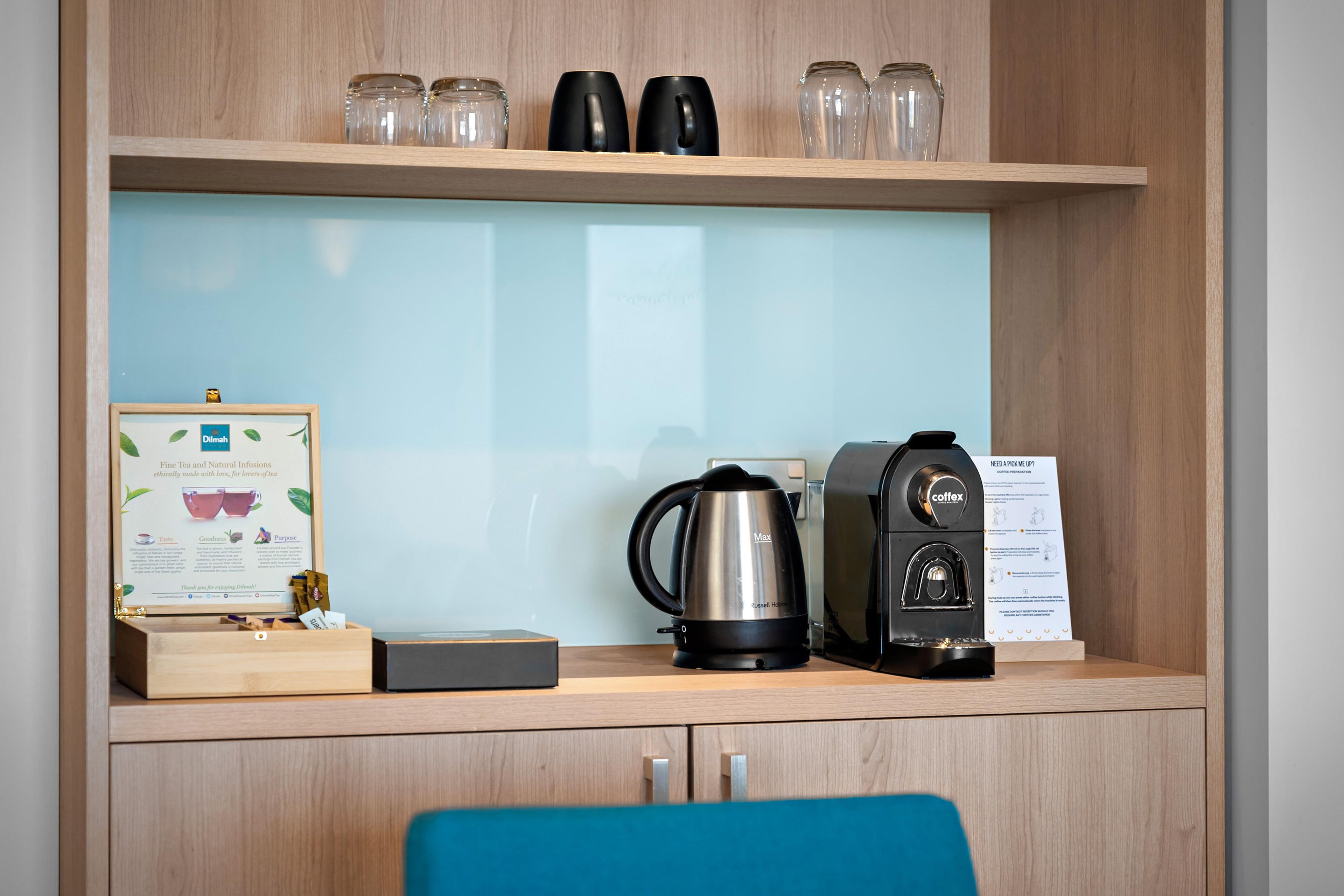 Un espace dédié au café, équipé d’une machine à café, d’une bouilloire et d’un panneau explicatif sur la préparation du café.