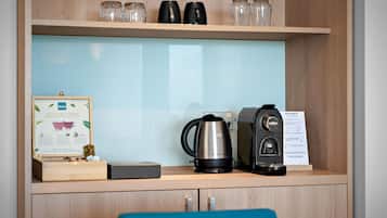 Un espace dédié au café, équipé d’une machine à café, d’une bouilloire et d’un panneau explicatif sur la préparation du café.