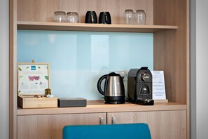 A coffee station with a coffee maker, a kettle, and a sign about coffee preparation. - Sudima Christchurch Airport (Christchurch)