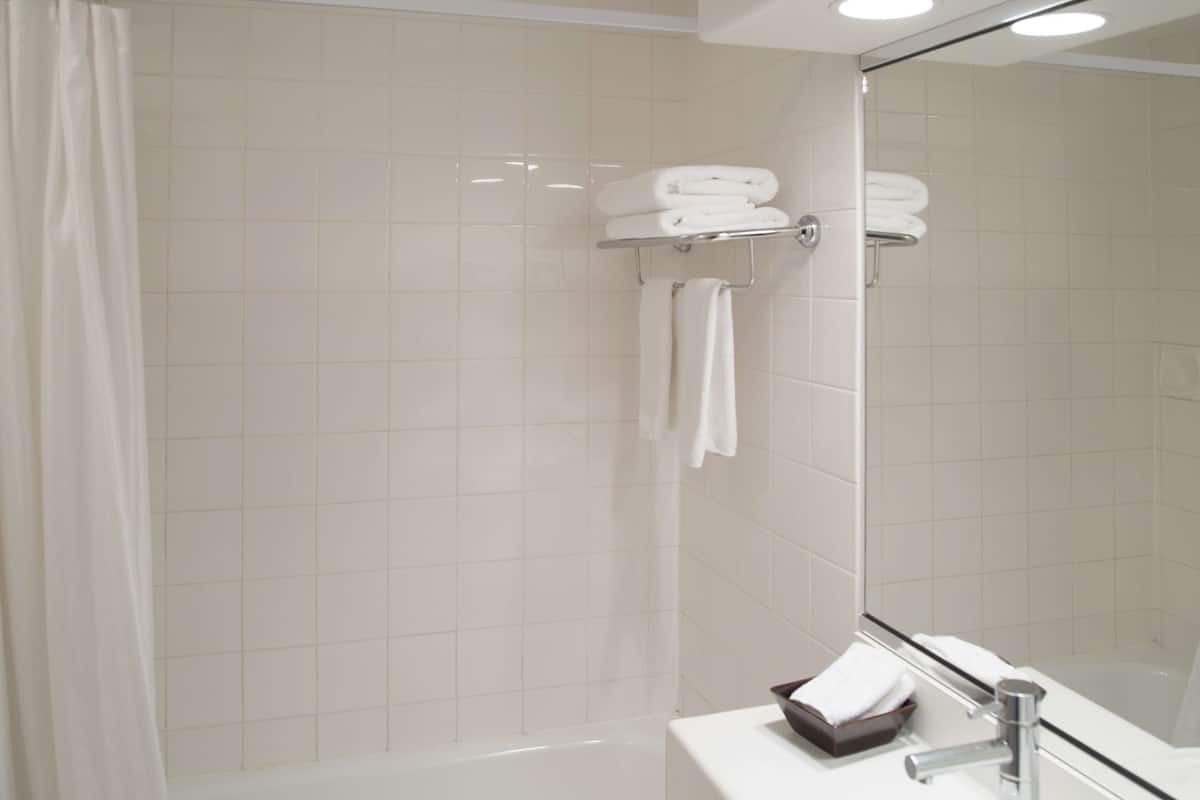 A modern bathroom with a shower, a sink, and a mirror.