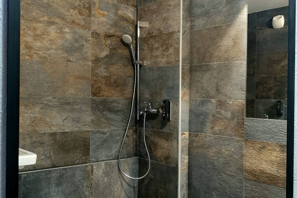 Une salle de bain moderne équipée d’une douche, de toilettes et d’un lavabo.