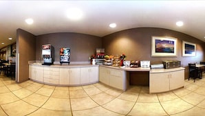 A reception area with a curved counter, vending machines, and a small dining area with chairs and tables. - Motel 6 Bernalillo, NM (Bernalillo)