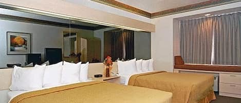 Una habitación de hotel con dos camas, un espejo grande, una televisión y una ventana con cortinas.