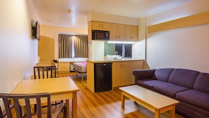 A compact living space with a kitchenette, a dining area, and a seating area. - Motel 6 Bernalillo, NM (Bernalillo)