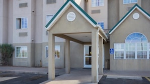 A building with a covered entrance, multiple windows, and a van accessible sign. - Motel 6 Bernalillo, NM (Bernalillo)