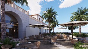 An outdoor patio with tables and chairs, palm trees, and a view of the ocean. - Bahia Principe Explore Costa Adeje – Hyatt Inclusive Collection (Adeje)