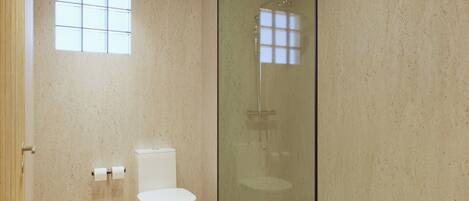 A bathroom with a toilet, a glass-enclosed shower, and a small window.