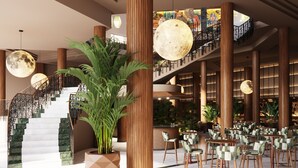 A spacious lobby with a grand staircase, large potted plants, and modern lighting fixtures. - Bahia Principe Explore Costa Adeje – Hyatt Inclusive Collection (Adeje)