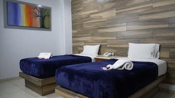 Ein Hotelzimmer mit zwei Betten, einem Holzkopfende und einem Gemälde an der Wand.