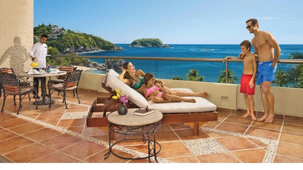 A terrace with a pool, lounge chairs, and a view of the ocean. - Dreams Huatulco Resort & Spa - All Inclusive (Santa María Huatulco)