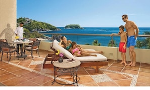 Una terraza con piscina, sillas de descanso y vistas al océano.