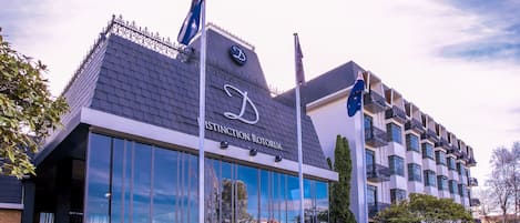 Un edificio moderno con un techo distintivo y grandes ventanales, que muestra el rótulo 'DISTINCTION ROYAL'.