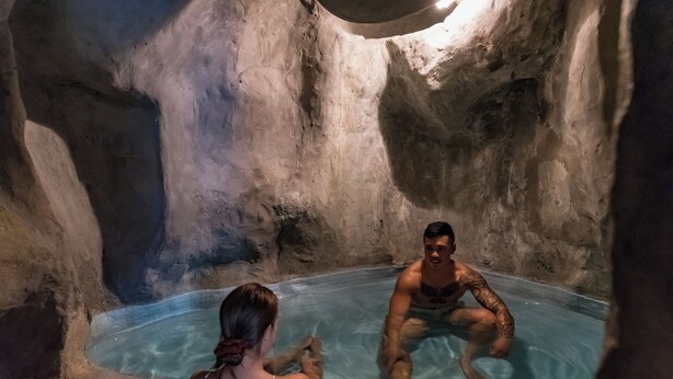 A man and a woman in a natural rock bath with clear water. - Distinction Rotorua Hotel and Conference Centre (Rotorua)