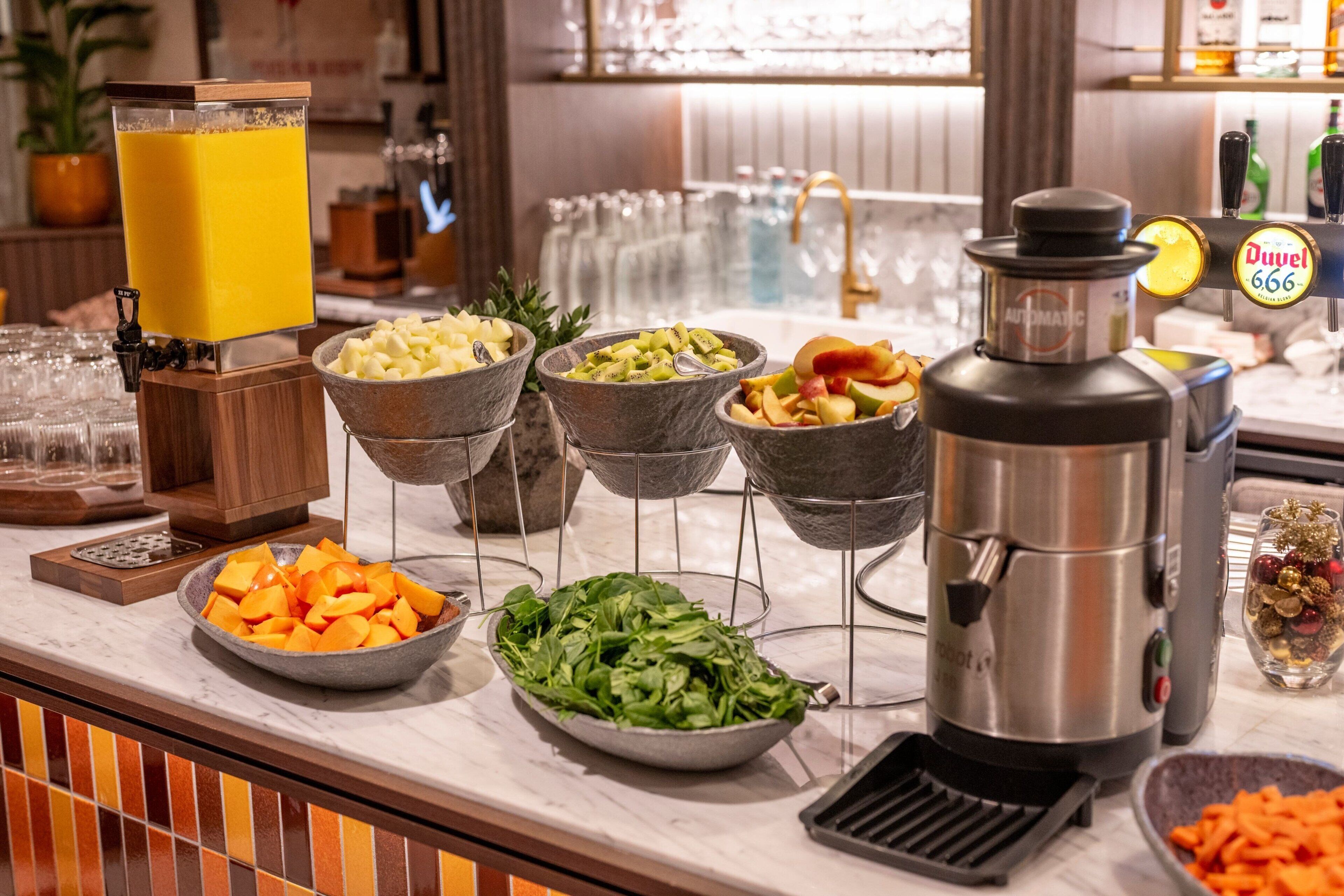 A buffet with various food items and a juice dispenser.