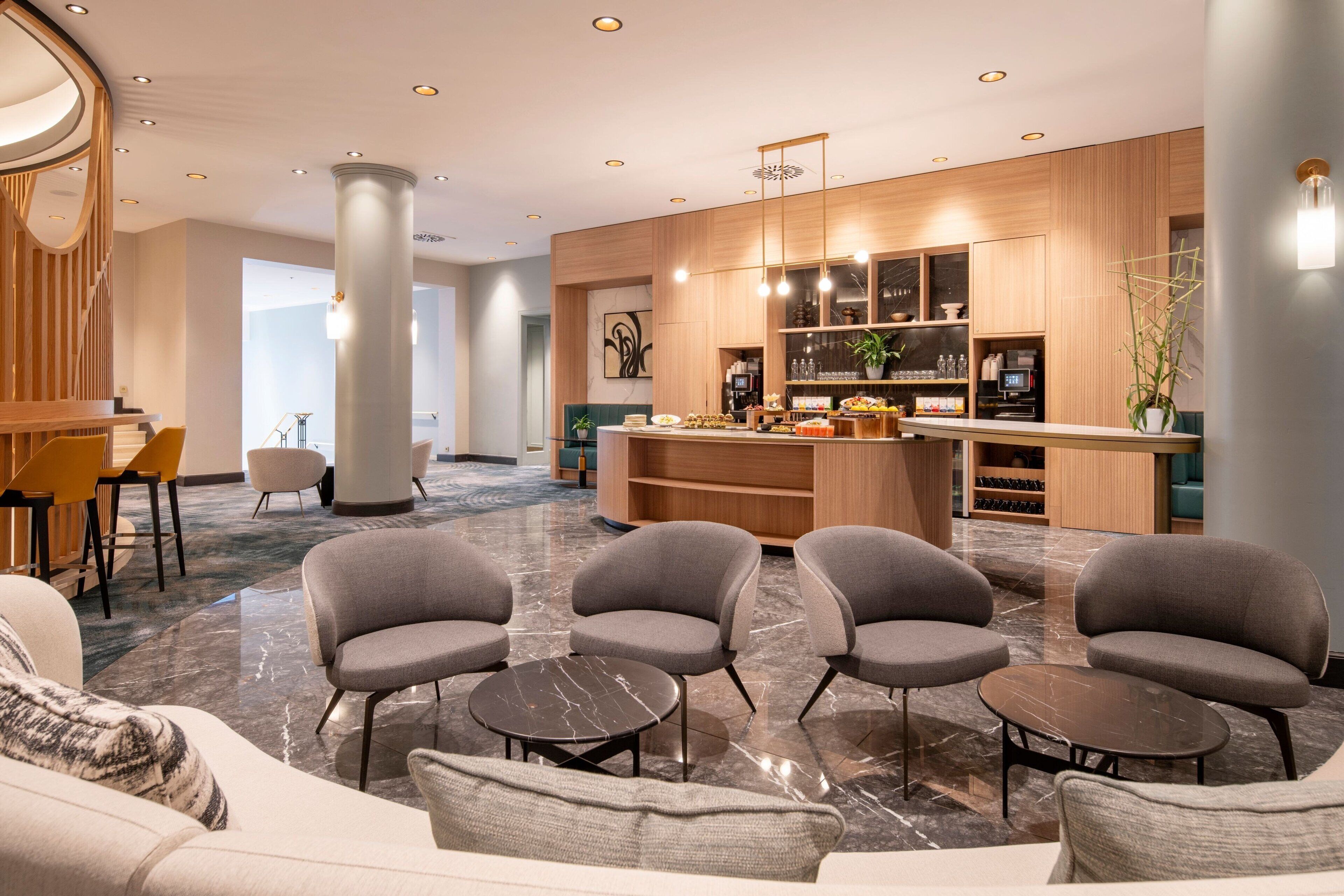 Um lobby moderno com área de estar, balcão de recepção e bar.