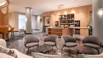 Um lobby moderno com área de estar, balcão de recepção e bar.