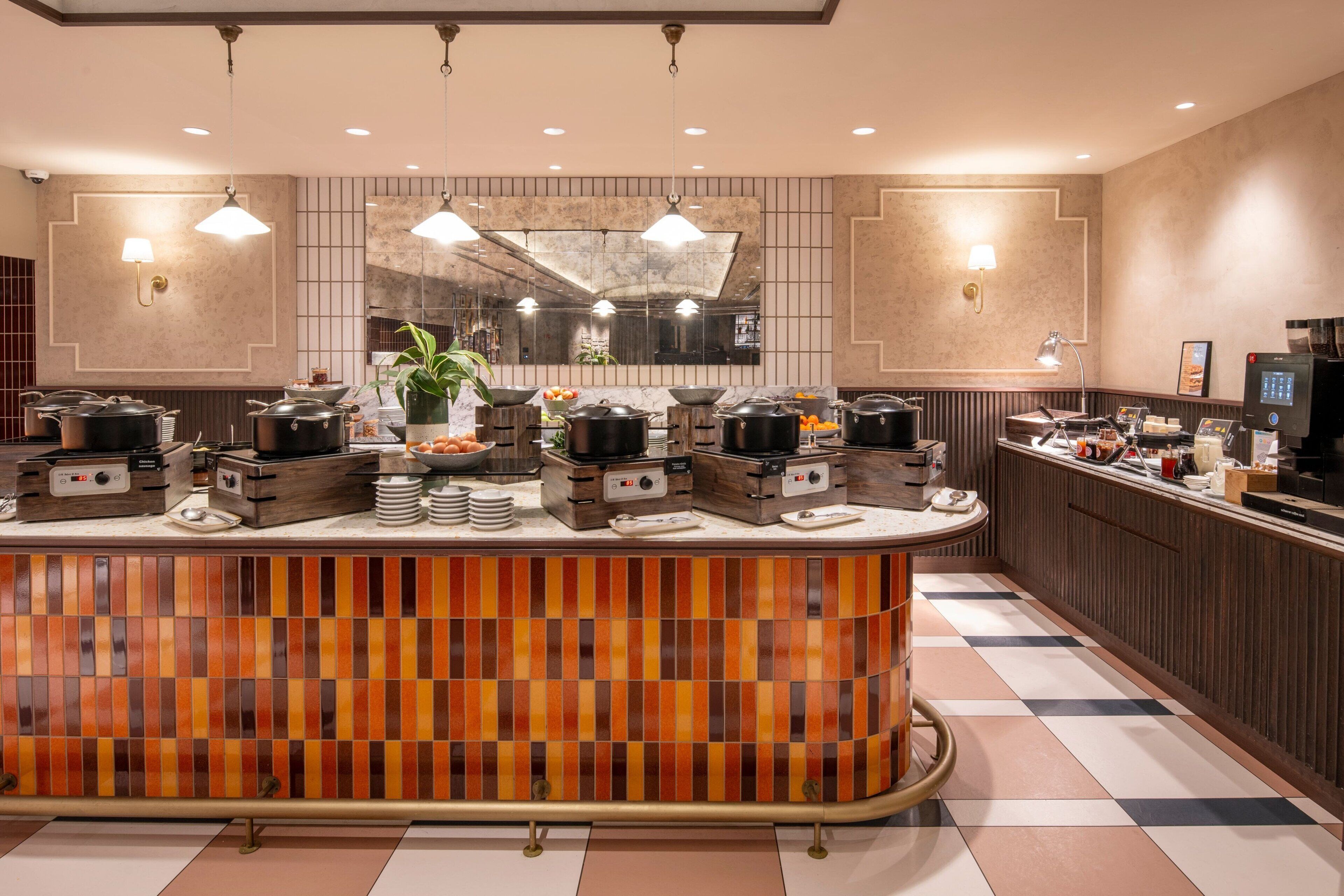 A modern kitchen with a central island, equipped with multiple cooking stations and a variety of appliances.