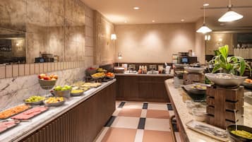 Buffet com diversos tipos de comida e um balcão de recepção.