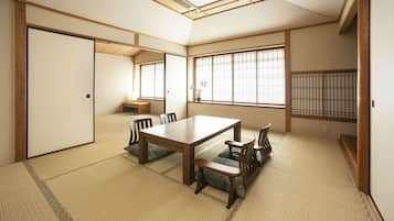 A traditional Japanese room with tatami flooring, a low table with chairs, and shoji screens.
