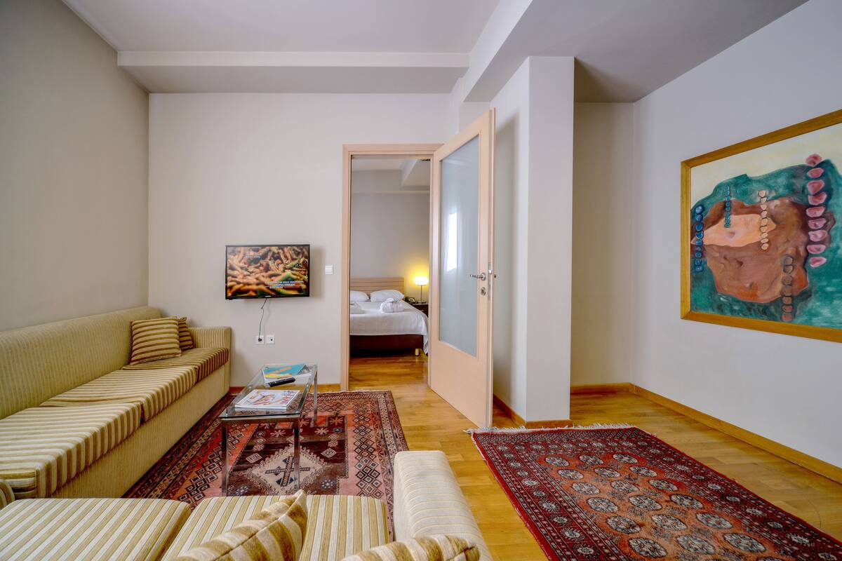 A living room with a sofa, a coffee table, and a painting on the wall.