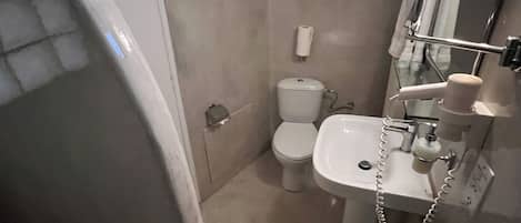 Un baño con inodoro, lavamanos y ducha.