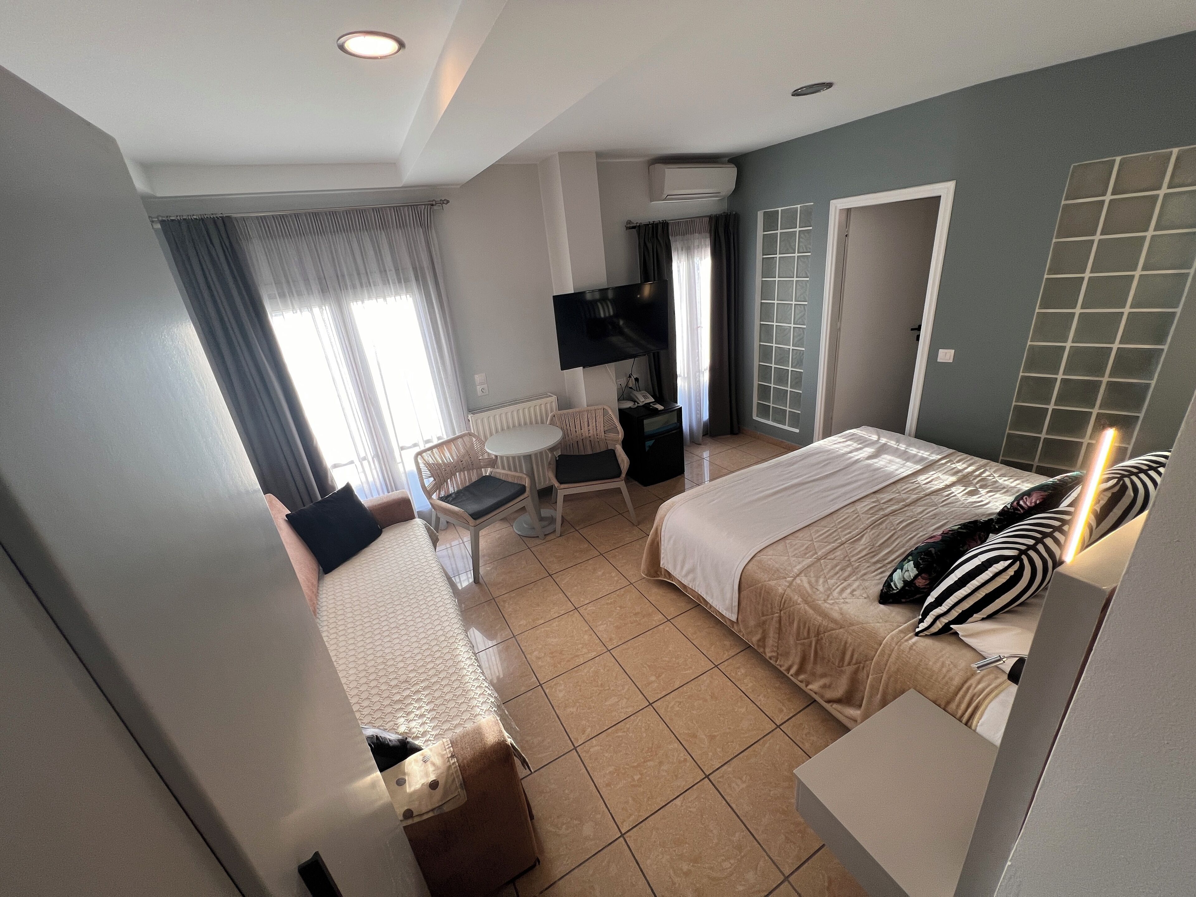 Ein Hotelzimmer mit Bett, Schreibtisch, Stuhl und Fernseher.