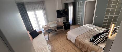 Una habitación de hotel con cama, escritorio, silla y televisor.