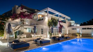 A modern two-story building with a swimming pool, outdoor seating, and a bar area. - Aressana Spa Hotel & Suites - Small Luxury Hotels of the World (Santorini)