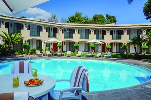 Una piscina al aire libre, sillones reclinables de piscina