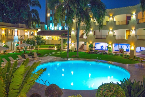 Una piscina al aire libre, sillones reclinables de piscina