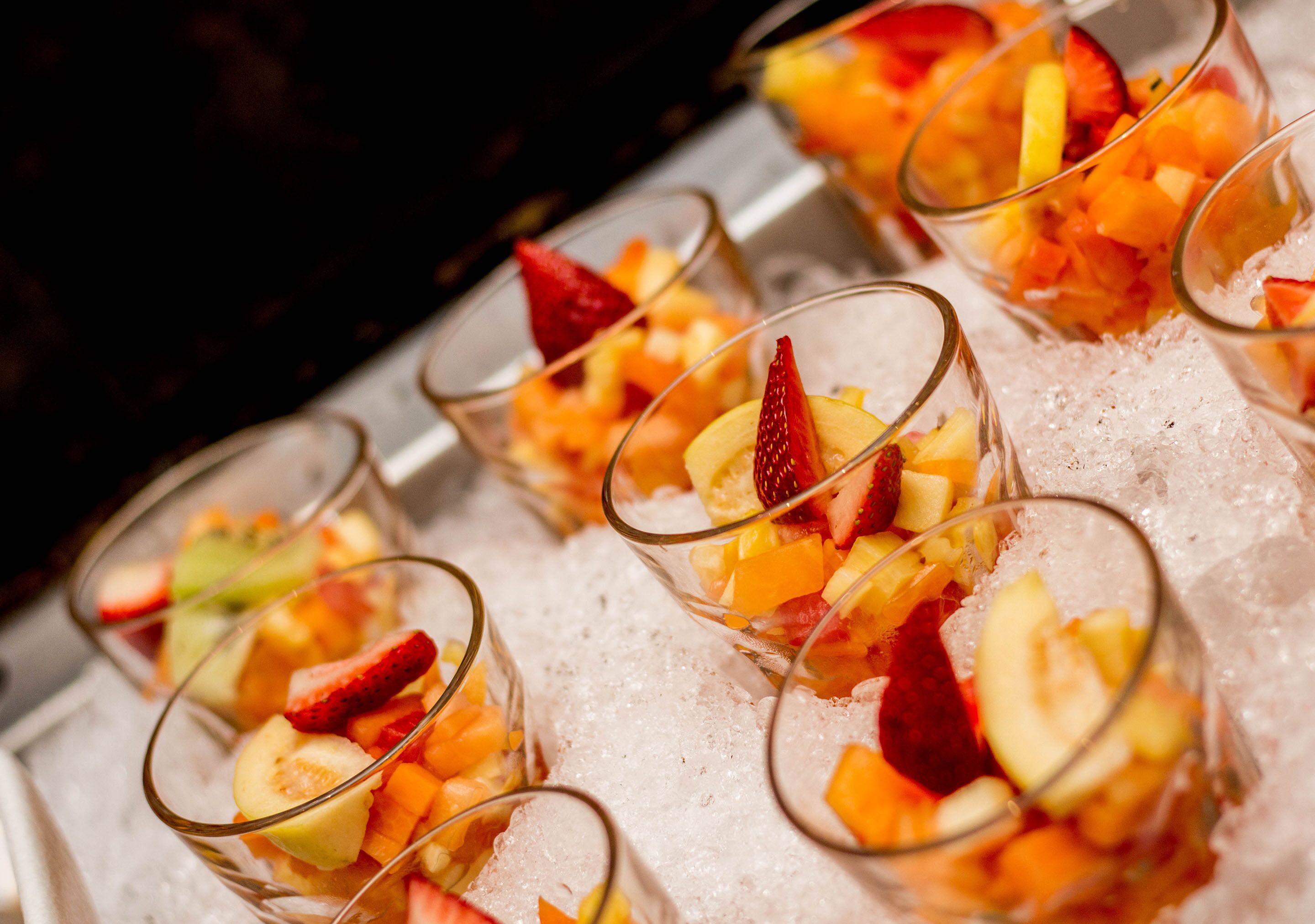 A tray of fruit cups on ice.