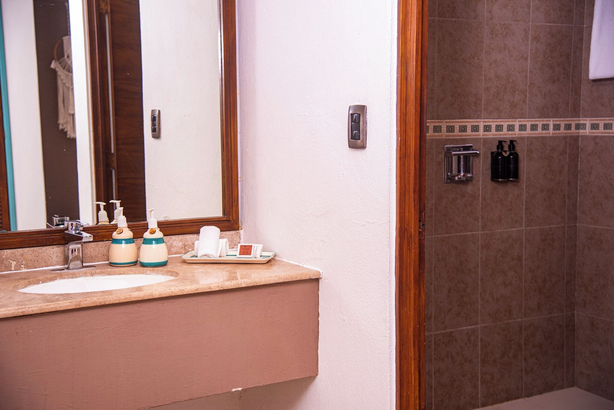 A bathroom with a sink, mirror, and toiletries.