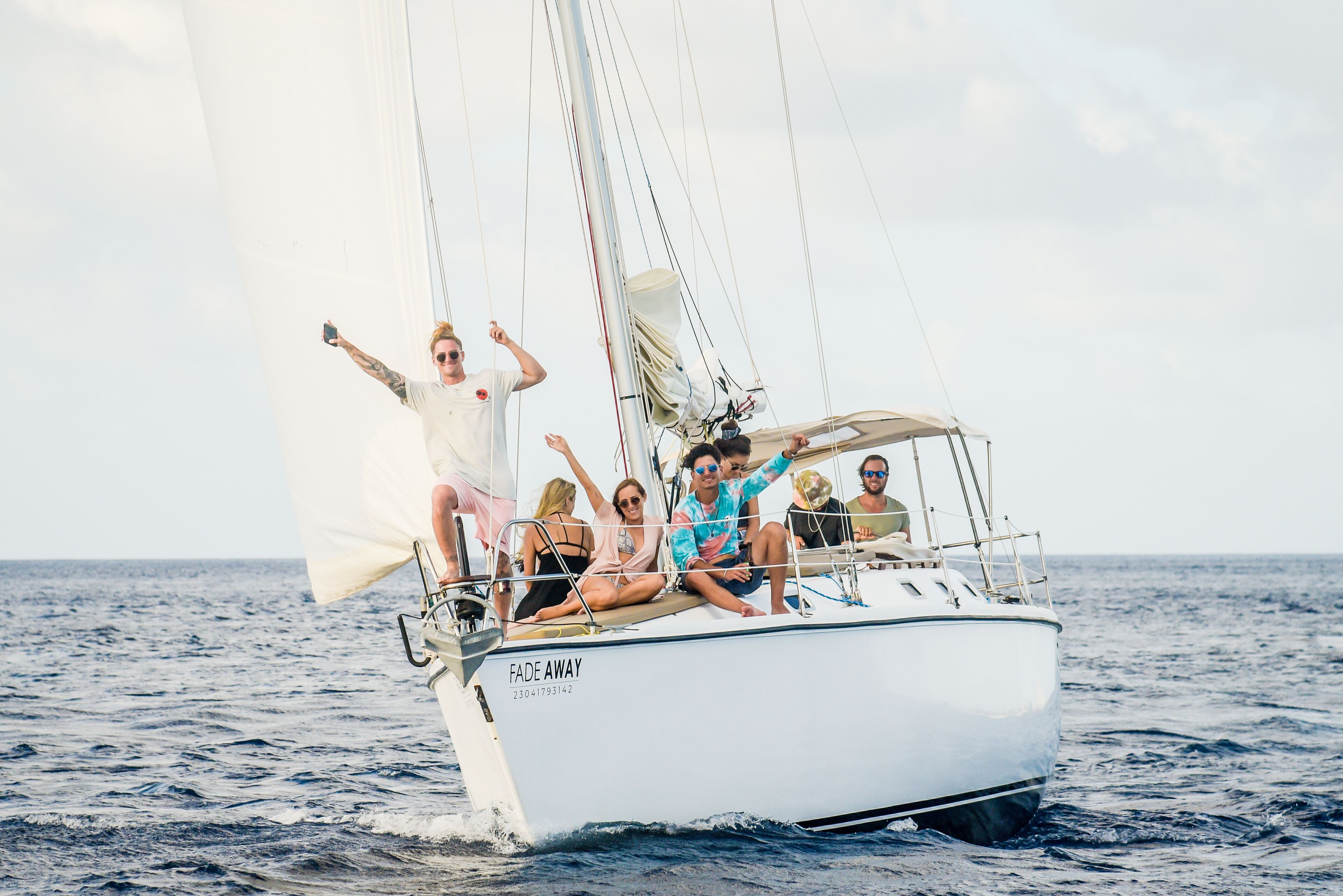 A sailboat with the name "FADE AWAY" on the side, sailing on the ocean.