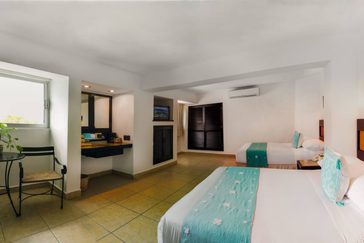 Une chambre d’hôtel comprenant un lit, un bureau, une chaise, une télévision et une armoire.